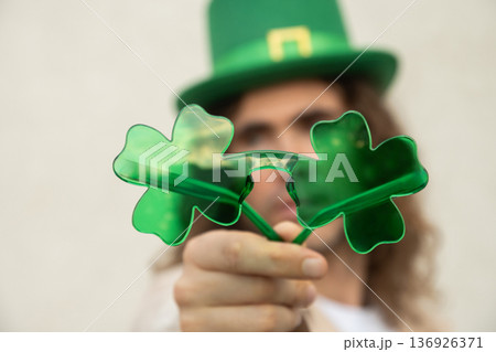 Man holding shamrock glasses celebrating St Patrick day Man holding shamrock glasses celebrating St Patrick day 136926371