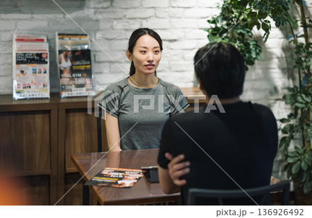 スポーツジムで手続きの説明を受ける女性 136926492