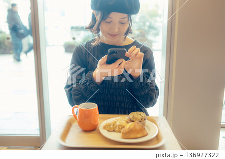 カフェでパンの写真を撮る日本人女性 カフェでパンの写真を撮る日本人女性 136927322