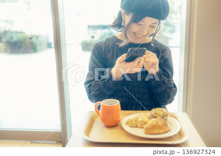 カフェでパンの写真を撮る日本人女性 カフェでパンの写真を撮る日本人女性 136927324