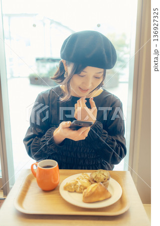 カフェでパンの写真を撮る日本人女性 カフェでパンの写真を撮る日本人女性 136927325