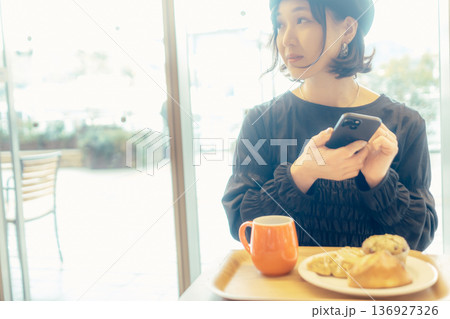 カフェでパンの写真を撮る日本人女性 136927326