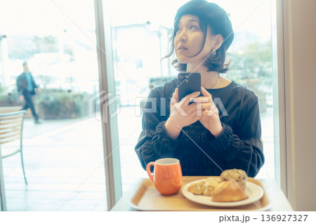 カフェでパンの写真を撮る日本人女性 136927327