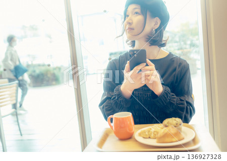 カフェでパンの写真を撮る日本人女性 136927328
