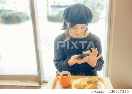 カフェでパンの写真を撮る日本人女性 136927330