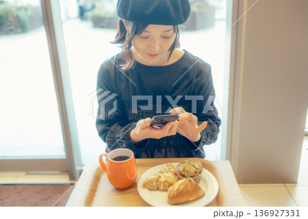 カフェでパンの写真を撮る日本人女性 136927331