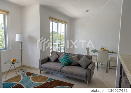 Bright living room with sliding glass door to balcony 136927481
