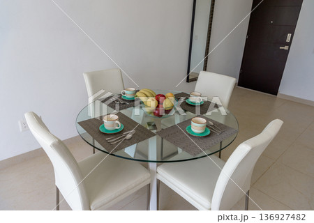 Round glass dining table set for four with fruit Round glass dining table set for four with fruit 136927482