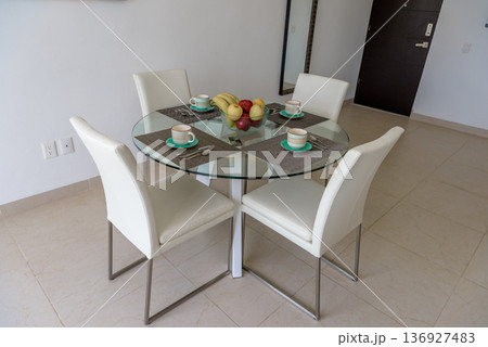 Modern dining table with white chairs and fruit bowl Modern dining table with white chairs and fruit bowl 136927483