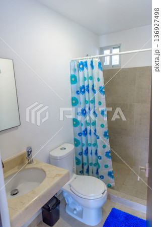 Bathroom with floral shower curtain and blue accents Bathroom with floral shower curtain and blue accents 136927498