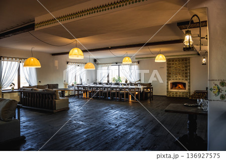 Spacious banquet hall with fireplace and large dining table 136927575