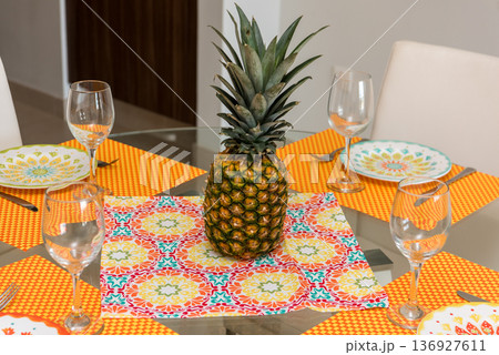 Fresh pineapple centerpiece on colorful table runner close up 136927611