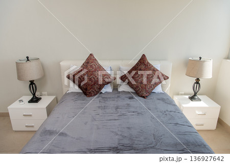 Symmetrical bedroom setup with lamps and pillows Symmetrical bedroom setup with lamps and pillows 136927642
