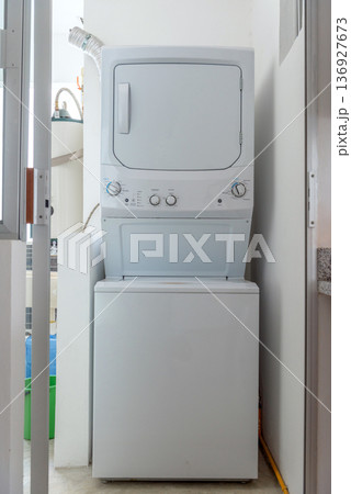 Stacked washer and dryer in apartment laundry area Stacked washer and dryer in apartment laundry area 136927673