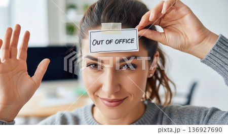 Woman smiling showing out of office status note 136927690