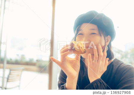 カフェでパンを食べる日本人女性 136927908