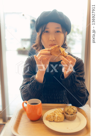 カフェでパンを食べる日本人女性 136927911