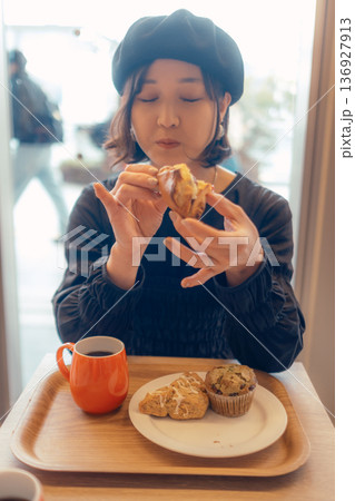 カフェでパンを食べる日本人女性 カフェでパンを食べる日本人女性 136927913