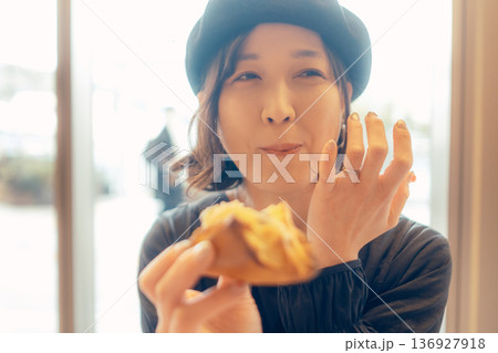 カフェでパンを食べる日本人女性 136927918