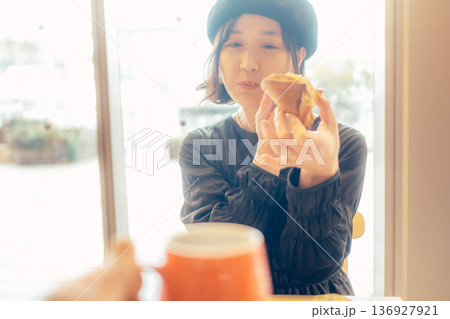 カフェでパンを食べる日本人女性 136927921