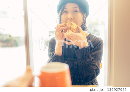 カフェでパンを食べる日本人女性 136927923