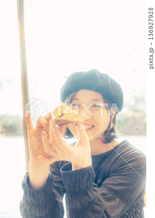 カフェでパンを食べる日本人女性 136927928