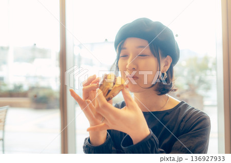カフェでパンを食べる日本人女性 136927933