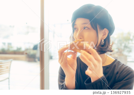 カフェでパンを食べる日本人女性 136927935