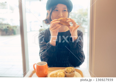 カフェでパンを食べる日本人女性 136927939