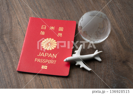 赤い日本のパスポートと飛行機と地球のミニチュア 赤い日本のパスポートと飛行機と地球のミニチュア 136928515