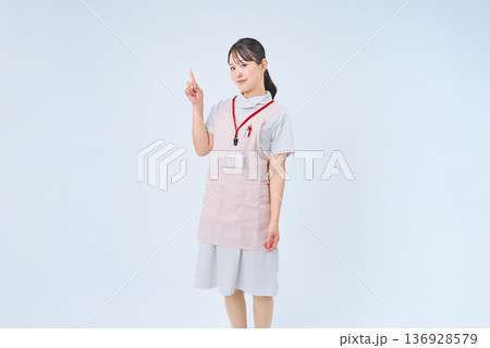 指を立てるポーズをする白衣の女性 指を立てるポーズをする白衣の女性 136928579
