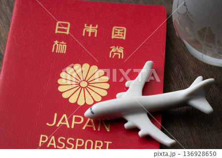 赤い日本のパスポートと飛行機と地球のミニチュア 赤い日本のパスポートと飛行機と地球のミニチュア 136928650