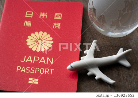 赤い日本のパスポートと飛行機と地球のミニチュア 赤い日本のパスポートと飛行機と地球のミニチュア 136928652