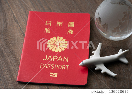 赤い日本のパスポートと飛行機と地球のミニチュア 赤い日本のパスポートと飛行機と地球のミニチュア 136928653