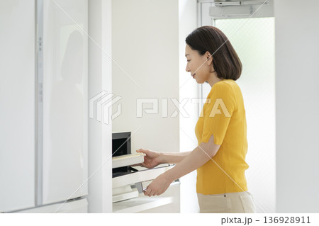 電子レンジでお弁当を温める50代の女性 電子レンジでお弁当を温める50代の女性 136928911