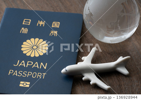 青色の日本のパスポートと飛行機と地球のミニチュア 136928944