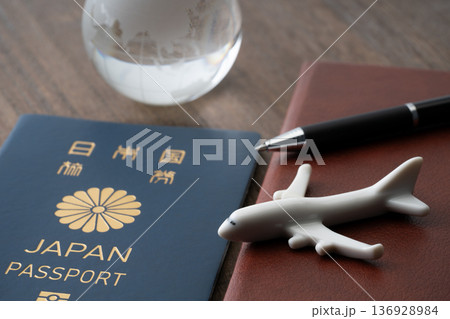 青色の日本のパスポートと手帳に飛行機と地球のミニチュア 青色の日本のパスポートと手帳に飛行機と地球のミニチュア 136928984