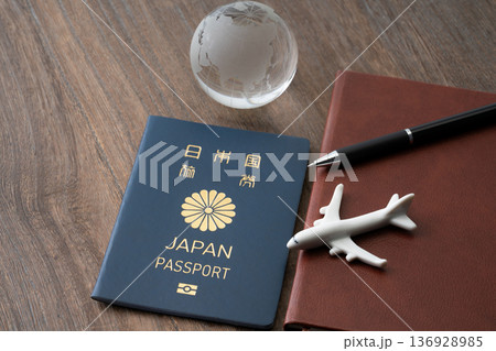 青色の日本のパスポートと手帳に飛行機と地球のミニチュア 136928985