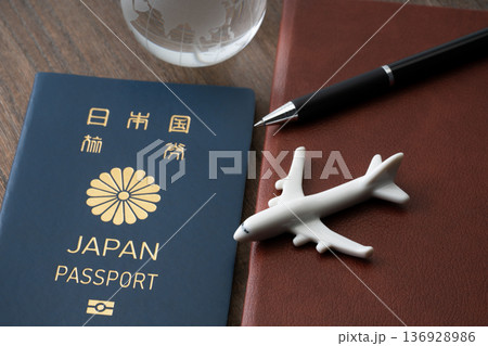 青色の日本のパスポートと手帳に飛行機と地球のミニチュア 136928986