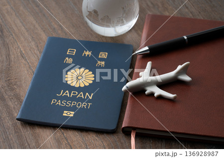 青色の日本のパスポートと手帳に飛行機と地球のミニチュア 136928987
