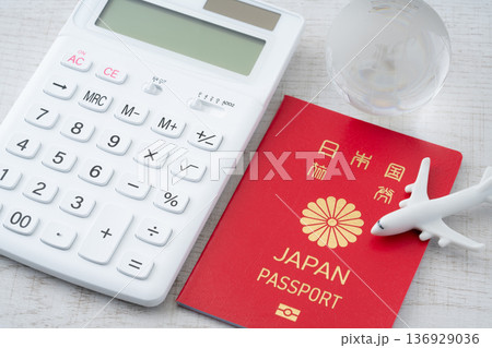 赤い日本のパスポートと電卓に飛行機と地球のミニチュア 赤い日本のパスポートと電卓に飛行機と地球のミニチュア 136929036