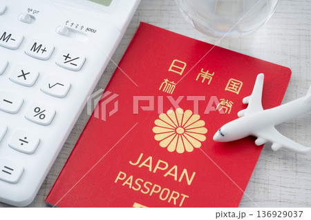 赤い日本のパスポートと電卓に飛行機と地球のミニチュア 赤い日本のパスポートと電卓に飛行機と地球のミニチュア 136929037