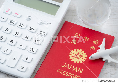 赤い日本のパスポートと電卓に飛行機と地球のミニチュア 136929038