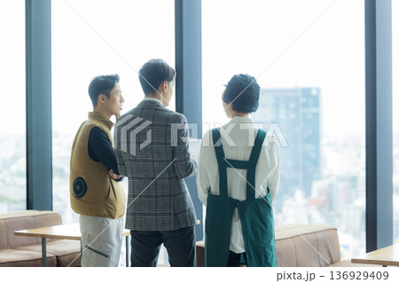 資料を見ながら打ち合わせする空調服の職人の男性 136929409