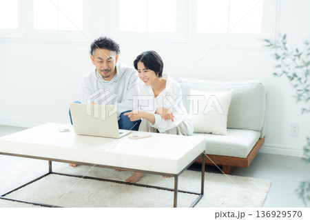 リビングでパソコンを見るミドル夫婦 リビングでパソコンを見るミドル夫婦 136929570