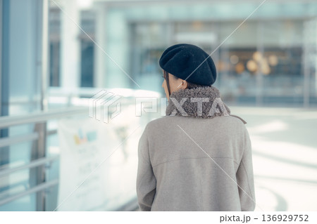 冬の街を歩きながら振り返る女性 136929752