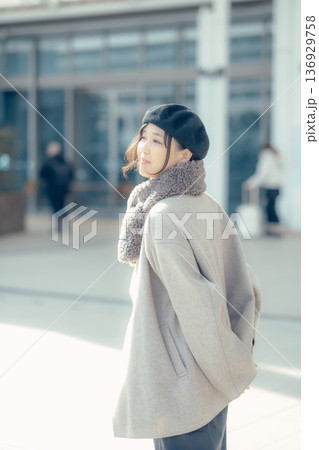 冬の街を歩きながら振り返る女性 136929758