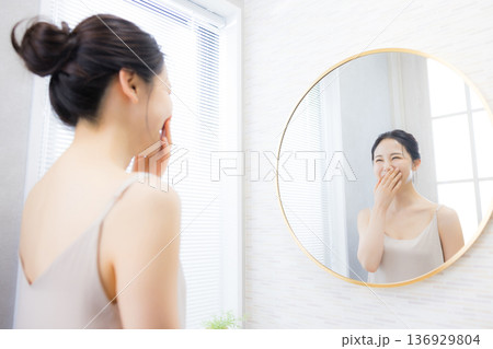 洗面所で鏡を見る若い女性 洗面所で鏡を見る若い女性 136929804