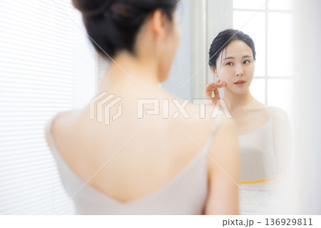 洗面所で鏡を見る若い女性　  136929811