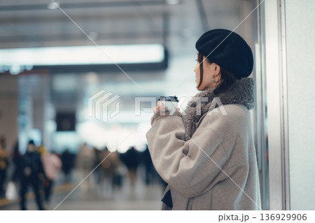 駅構内で待ち合わせをする冬の女性 駅構内で待ち合わせをする冬の女性 136929906
